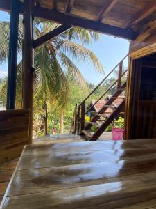 阿鲁甘湾Surf Beach Hotel的一个带楼梯和棕榈树的木甲板
