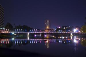 清迈RoomQuest Chiang Mai Tha Sala的夜间在水体上方的桥梁