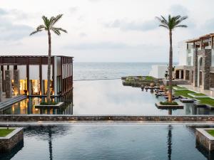 古瓦伊Amirandes Grecotel Boutique Resort的 ⁇ 染一个以海洋为背景的度假游泳池