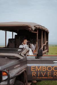 塔勒克Emboo River Camp的卡车后面的女人拍的照片