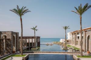 古瓦伊Amirandes Grecotel Boutique Resort的享有棕榈树度假村和大海的景致。