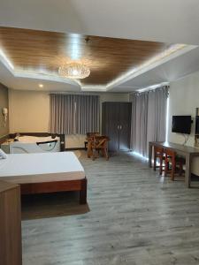 RosarioNorlu Cedec Midpoint Hotel的酒店客房设有床和客厅。