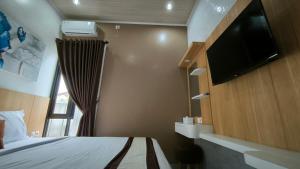 KalasanPremier Homestay Syariah的一间卧室配有一张床和一台平面电视