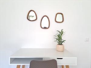 艾罗洛Airolo Valley Apartments by Quokka 360 - Cozy with Mountain View的一张带盆栽和三面镜子的白色书桌