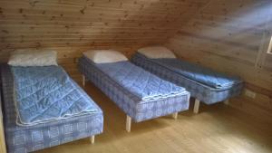 ÕrsavaPeko Holiday Home的小屋内的一个房间里设有三张床
