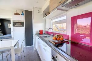 HudimesnilCottage Premium, camping 5* avec parc aquatique的厨房配有带水槽的柜台和窗户。
