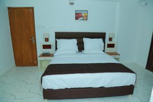 古鲁瓦尤尔Utsavam Hotel Apartments的一间卧室设有一张大床和一扇木门
