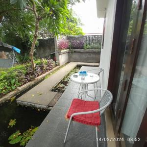 罗威那Lovina Villa Cinta的一个带桌椅的庭院和一个池塘
