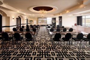 格拉德贝克格拉德贝克凡德瓦克酒店的一间会议室,配有桌椅和吊灯
