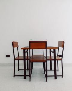 瓦塔穆Trio Villas Watamu的两张椅子、一张木桌、一张桌子和两把椅子
