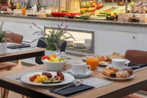马德里加泰罗尼亚太阳门酒店的餐桌上摆放着早餐食品和咖啡盘