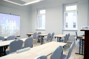 弗罗茨瓦夫波尼亚中枢酒店的配有桌椅和投影屏幕的教室