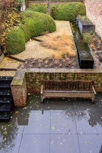 圣特雷登Sint-Truiden, Gootstraat 11的一个带两个长椅和砖墙的公园
