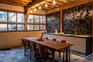 圣特雷登Sint-Truiden, Gootstraat 11的厨房配有木桌和一些窗户。