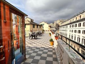 热那亚加拉塔酒店的阳台设有格子地板、桌子和建筑