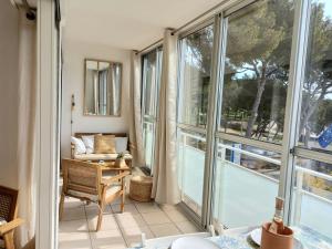 博尔马斯·莱斯·米默萨斯T2 - Centre ville - proche plage的客房设有大窗户 和阳台椅子