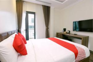 下龙湾Hạ Long Legend Hotel的一间卧室配有一张带红色枕头的床和电视。