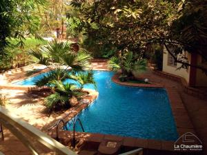 巴马科Hotel la chaumiere的享有棕榈树游泳池的顶部景致