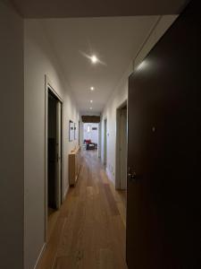 内图诺Miramare的一条铺有木地板的空走廊和一扇门