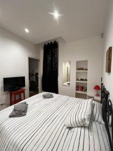 内图诺Miramare的卧室配有一张大白色床和电视。