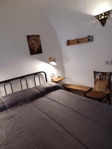 阿尔贝罗贝洛Trullo Vacanza的卧室配有1张床、1张桌子和1把椅子