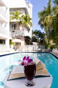 迈阿密海滩科瑞斯特套房酒店的一本书,在游泳池畔的桌子上喝一杯