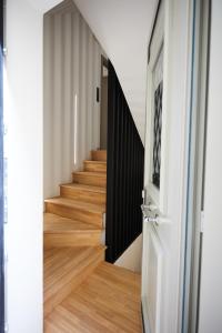 希俄斯Vasilicari Apartments的铺有木地板的走廊和白色的门