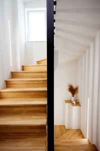 希俄斯Vasilicari Apartments的一座带木地板和窗户的房屋内的楼梯