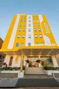 兰奇Bloom Hotel - Ranchi的黄色和白色的建筑,上面有欢迎标志