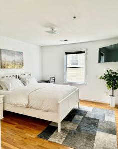 纽瓦克Stylish Evergreen Apartment By Newark Airport的白色的卧室设有白色的床和窗户。
