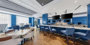 盖恩斯维尔佛罗里达大学会议中心盖恩斯维尔希尔顿酒店的一间拥有蓝色墙壁和椅子的餐厅和一间酒吧