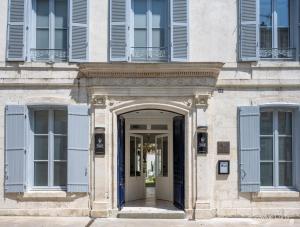 拉罗谢尔Villa Grand Voile - Christopher Coutanceau的带有蓝色百叶窗的建筑入口