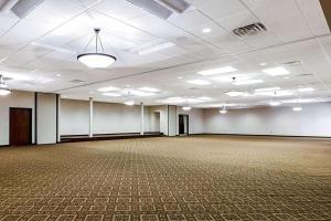 詹姆斯镇Baymont by Wyndham Jamestown Conference Center & Water Park的一间空房间,设有白色墙壁的大宴会厅