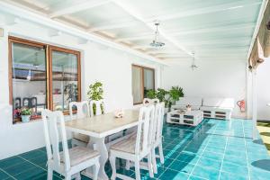 阿罗纳Villa Neon Tenerife的一间铺有蓝色地板并配有桌椅的用餐室