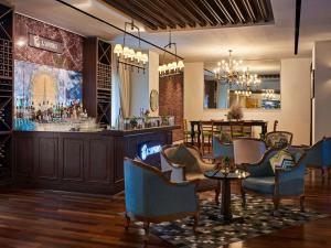 迪拜迪拜市区索菲特酒店的餐厅设有酒吧,配有椅子和桌子