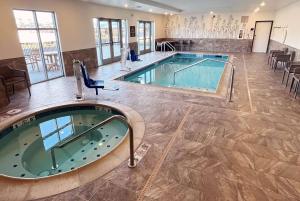 韦纳奇La Quinta Inn & Suites by Wyndham Wenatchee的一个带spa的酒店客房内的大型游泳池