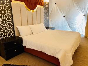 瓦迪拉姆Shaheen Camp Wadi rum的卧室配有一张带白色棉被的大床