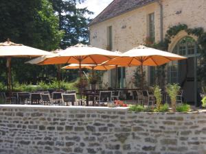 Pierre-PerthuisLes Deux Ponts的户外庭院配有桌椅和遮阳伞。