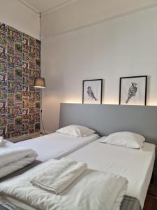 里斯本Castilho 63 Hostel & Suites的墙上有三张照片的房间的两张床
