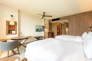 北芭堤雅Centara Grand Mirage Beach Resort Pattaya的一间卧室设有一张床和一间用餐室