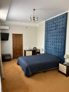 卡缅涅茨-波多利斯基In hotel的一间卧室配有一张蓝色的大床和蓝色的墙壁