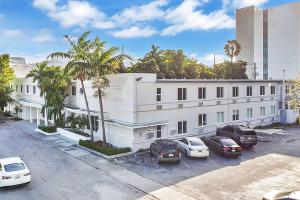 迈阿密Garden Hotel Miami Airport, Trademark Collection by Wyndham的白色的建筑,有汽车停在停车场