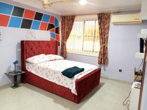 DodowaSANAMOND VILLA的一间卧室设有红色的床和窗户。