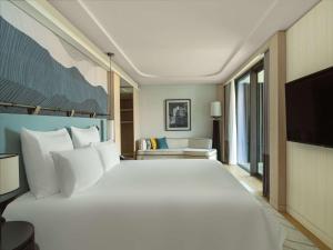 切什梅Swissotel Resort And Spa Cesme的酒店客房设有一张大床和一台电视。