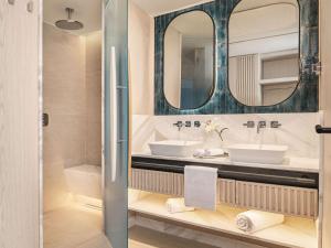 切什梅Swissotel Resort And Spa Cesme的浴室设有2个水槽和镜子