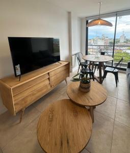 巴尔卡塞nardos suites的客厅配有大屏幕平面电视和桌子