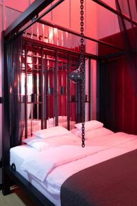 克拉科夫Exclusive BDSM Apartment Kraków - ADULTS ONLY的一间卧室设有一张带红色墙壁的大床