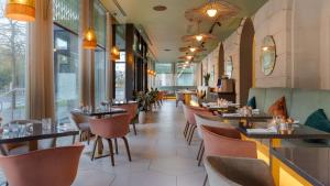 卡迪夫希尔顿加的夫酒店的餐厅设有桌椅和窗户。