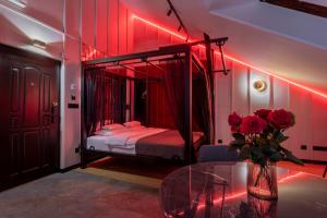 克拉科夫Exclusive BDSM Apartment Kraków - ADULTS ONLY的一间卧室配有一张红灯天蓬床
