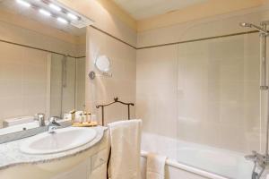 欧塞尔Hôtel Le Maxime - Best Western Signature Collection的一间带水槽、浴缸和淋浴的浴室
